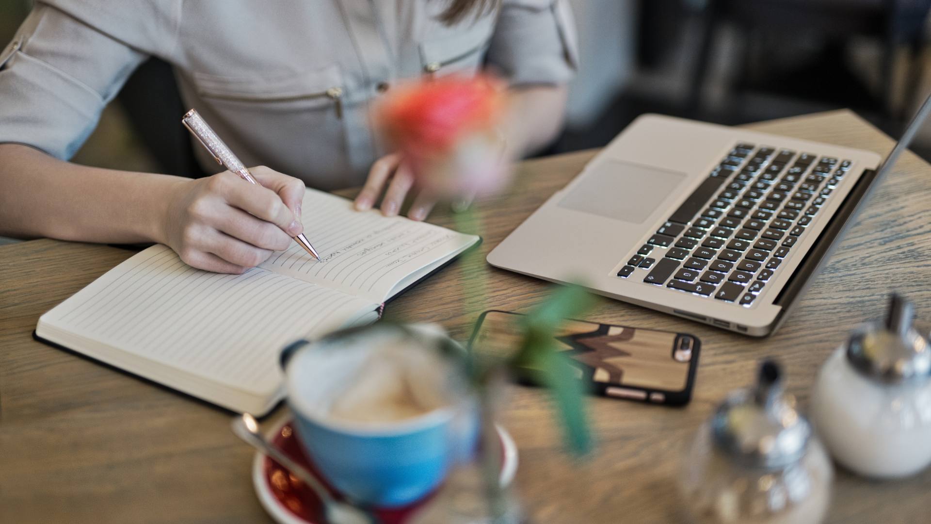 A person works on web design at a wooden desk.